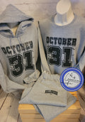 A set consisting of a gray hooded sweatshirt with 'OCTOBER 31' text on the front and matching gray sweatpants with Halloween vibes, displayed on mannequin busts.