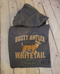 Hoodie with 'Rusty Antler Whitetail' design on a wooden surface