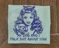 Tshirt with a graphic of a woman and dog and text 'My dog and I talk $hit about you!' on a wooden surface.