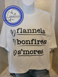 White tshirt displaying flannels, bonfires, s'mores on a mannequin.